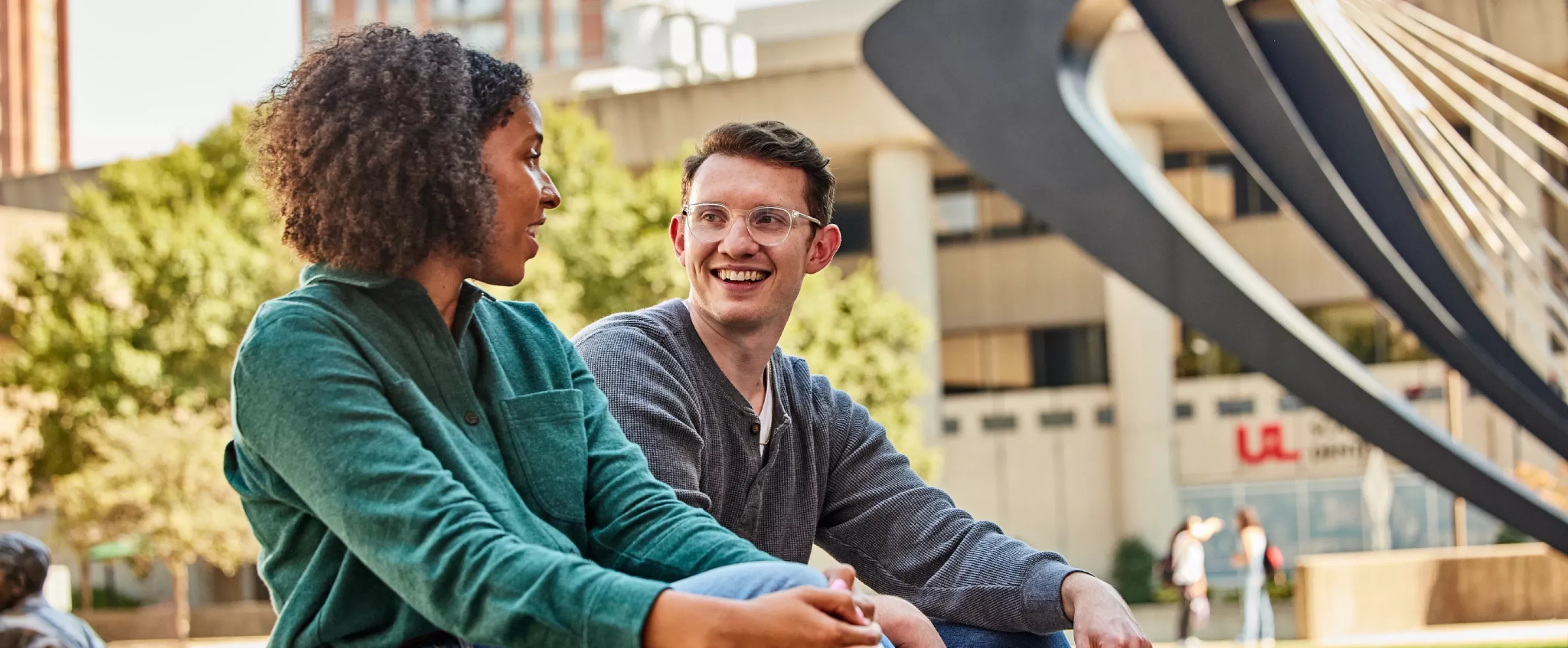 Two students have a pleasant conversation with each other in the HSC courtyard.