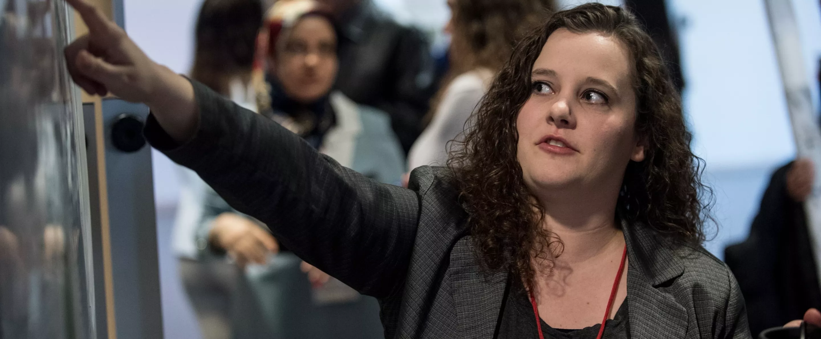 Student points to a board at the Graduate Research Conference.