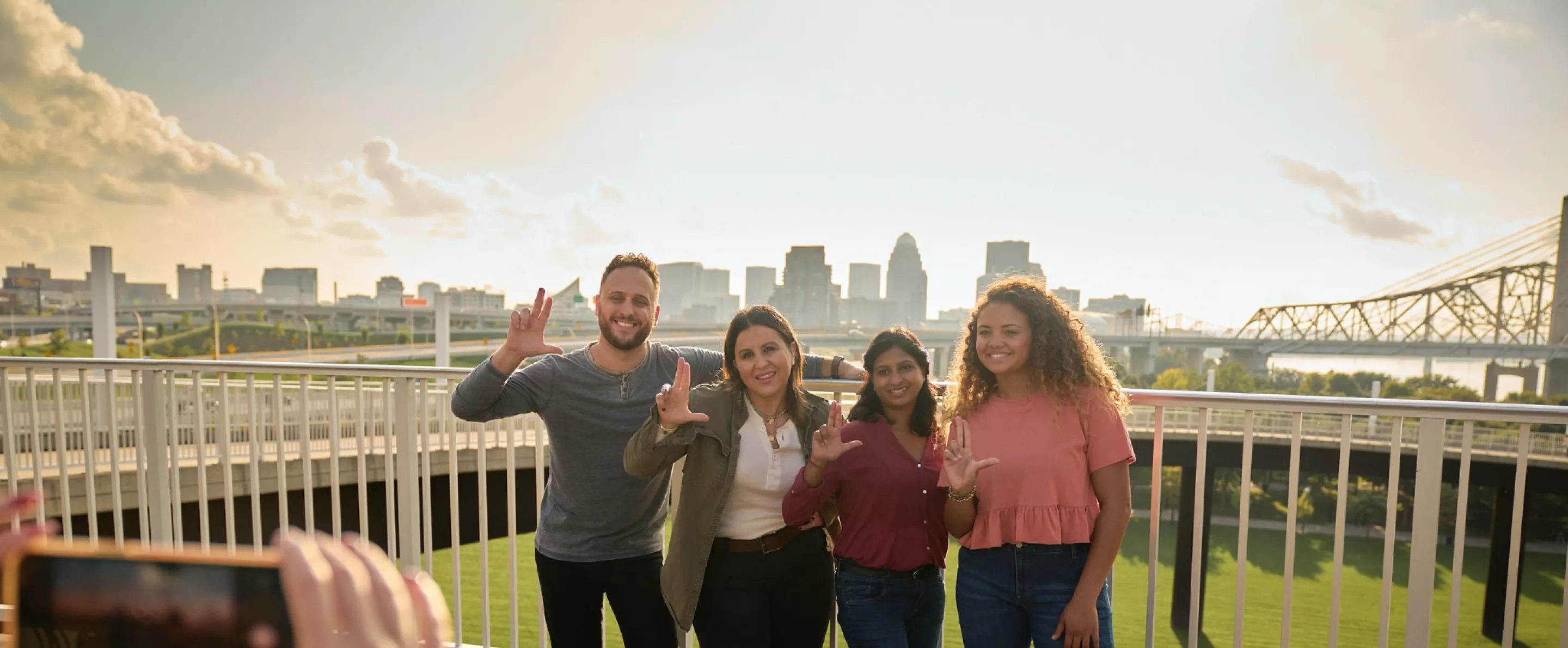 Students throwing up their L's for a group photo opportunity at the Big Four Bridge at Waterfront Park in downtown Louisville.