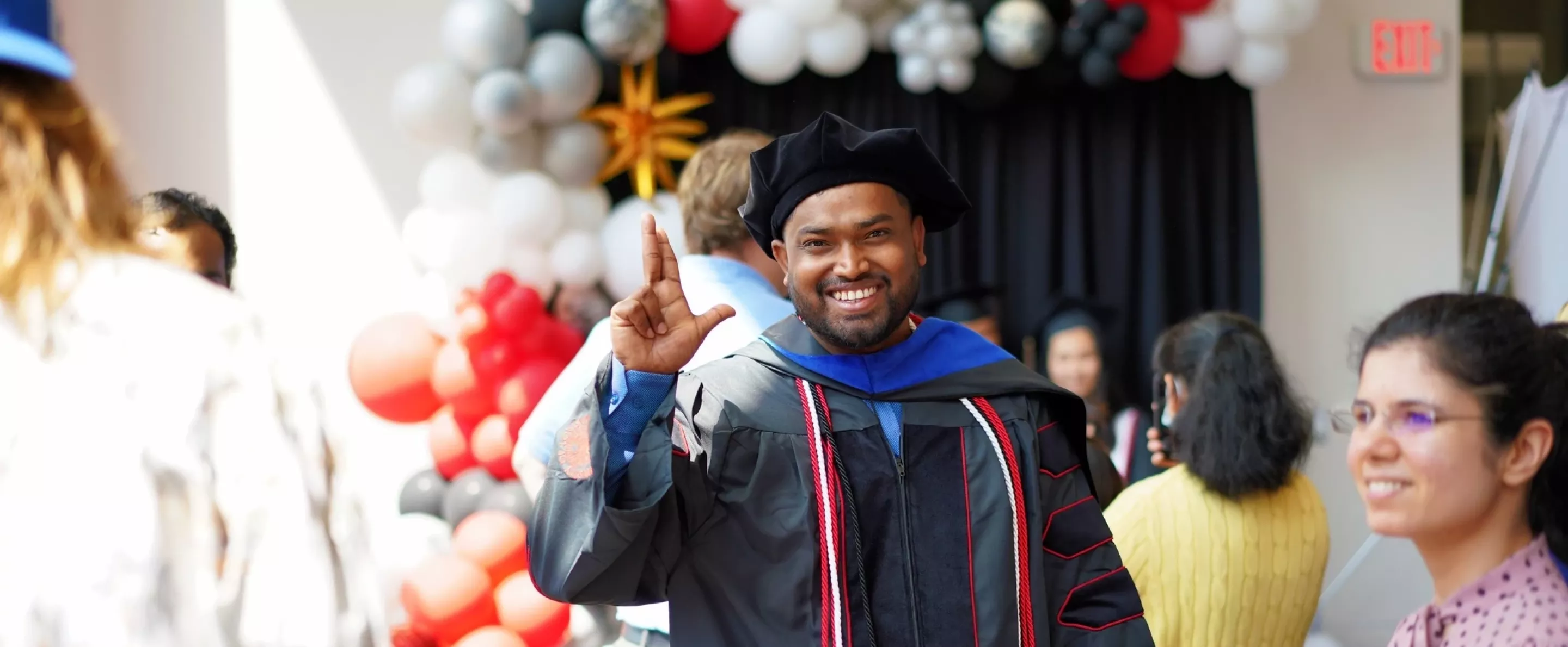 Student Raising L at Graduation
