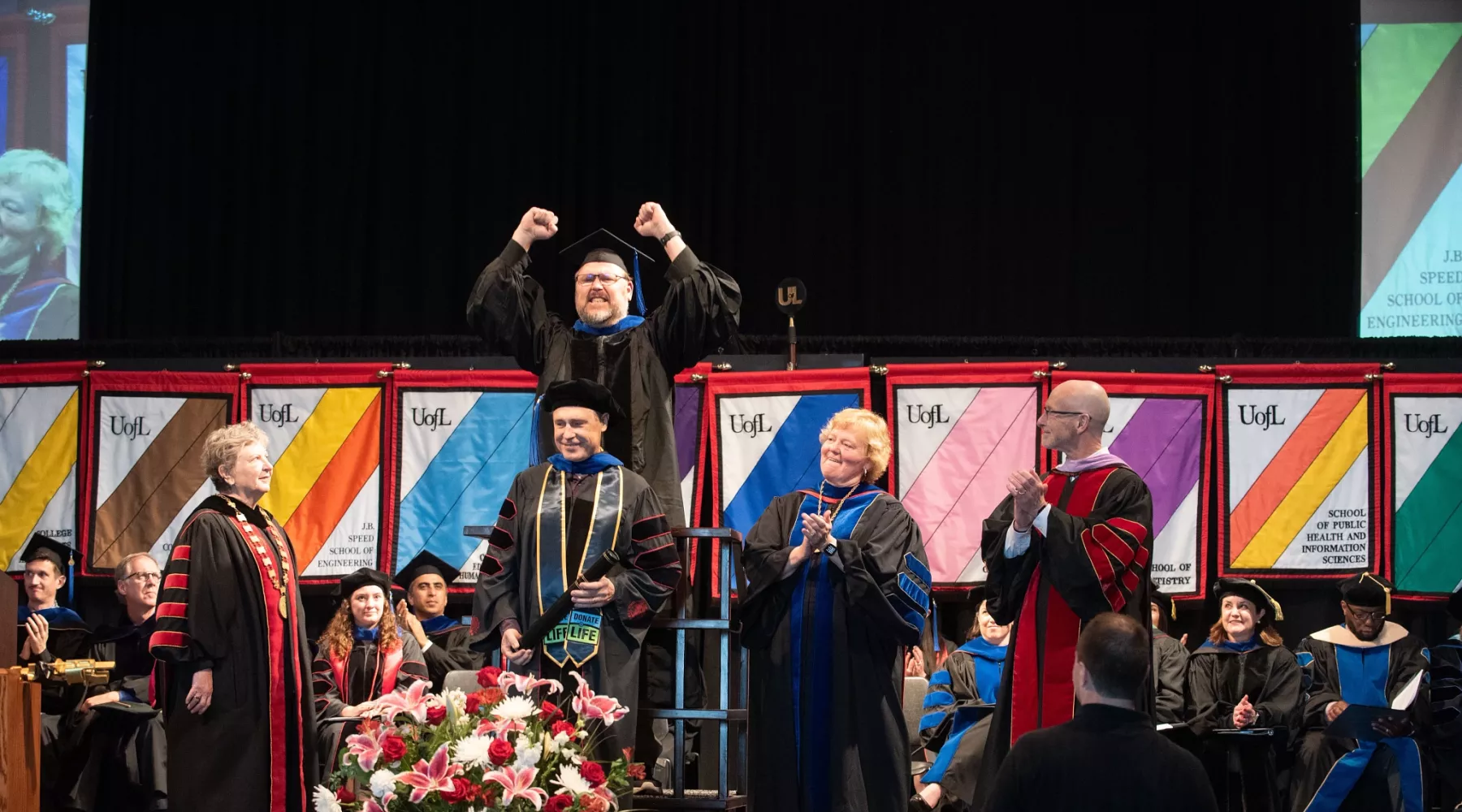 Faculty member cheering during hooding ceremony.