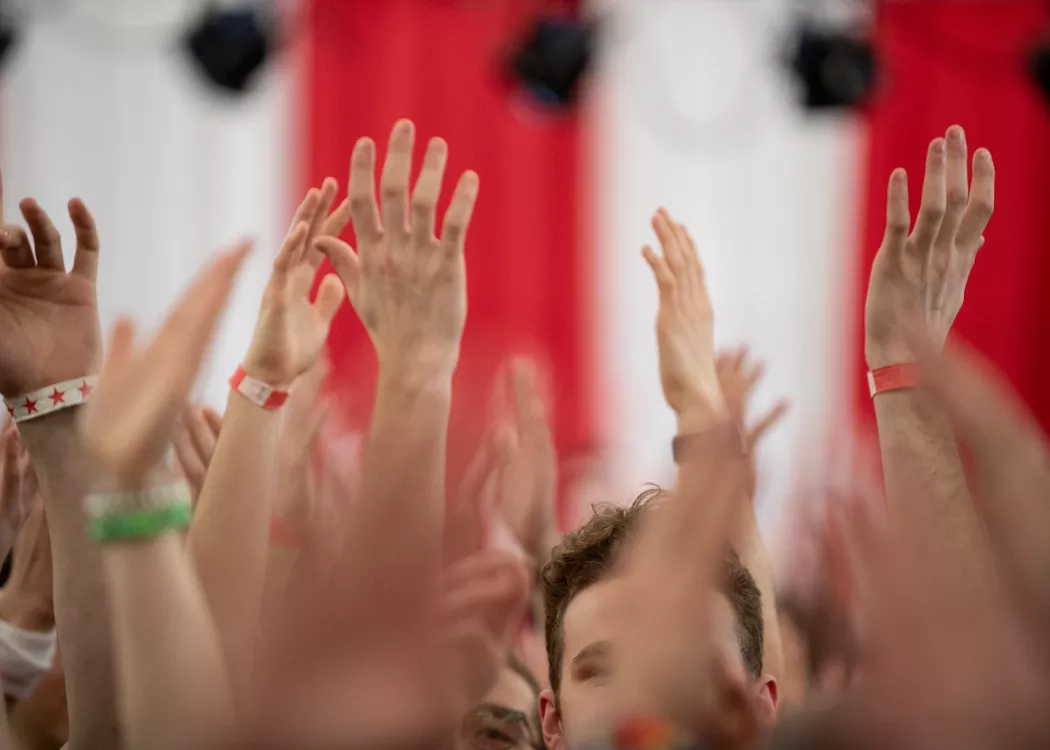 Image focused on hands in the air at raiseRED