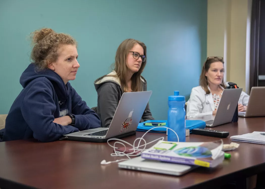 Students in SPHIS listen to their professor and take notes on their laptops