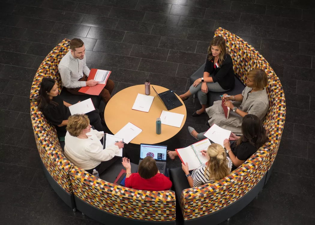 Group of employees having a conversation in a meeting while seated in the Belknap Academic Building