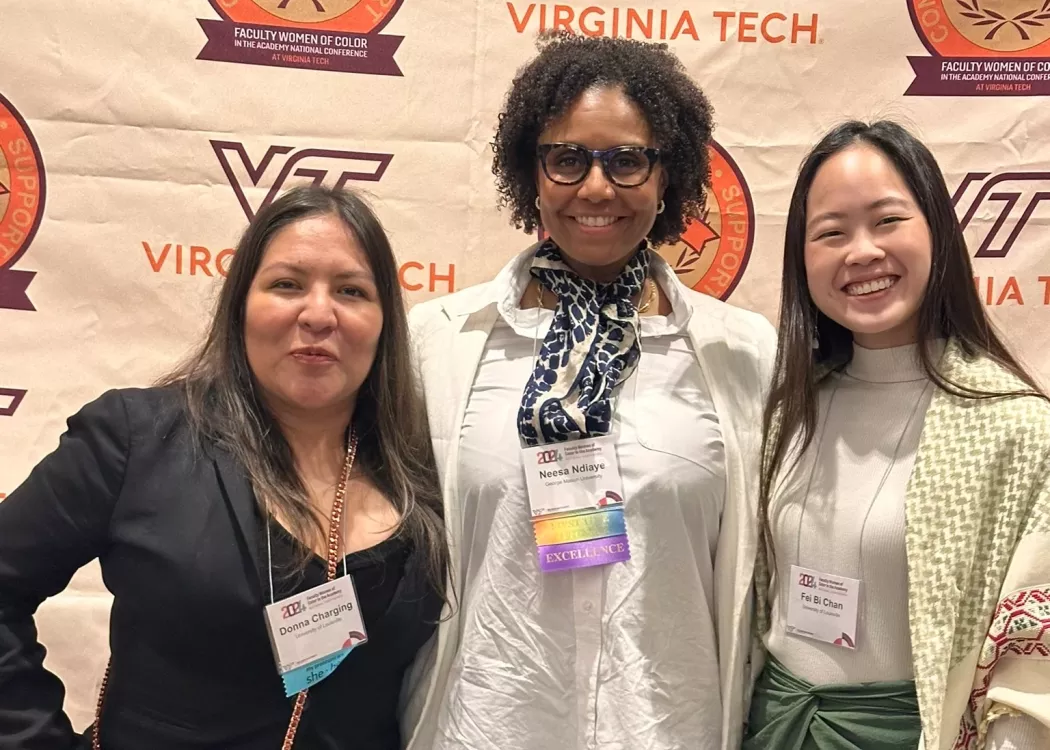 Two students and a faculty member pose for a photo at the Faculty Women of Color conference