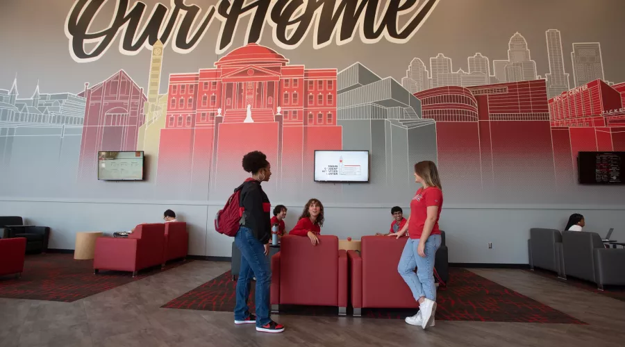 Two students chat with a seated student in the Student Activities Center
