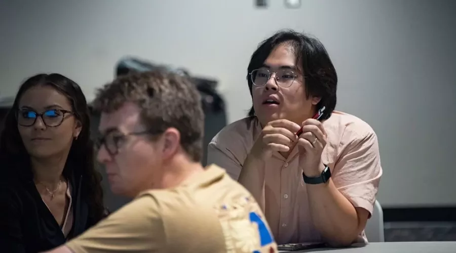 Three graduate students listening at a workshop.